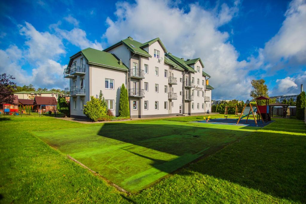 a large house with a playground in front of it at Kalmar in Darłówko