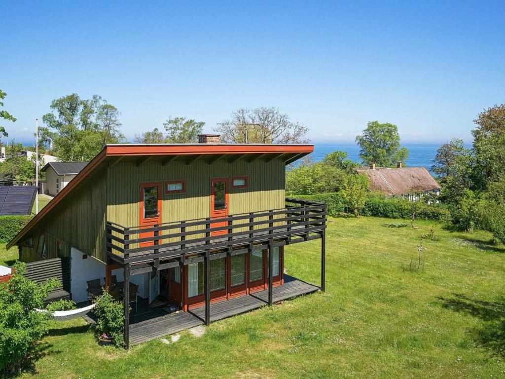 a small green house with a large deck at 8 person holiday home in Allinge in Allinge