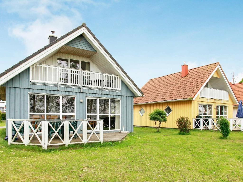 a house with a porch and a yellow house at 8 person holiday home in Gelting in Gelting