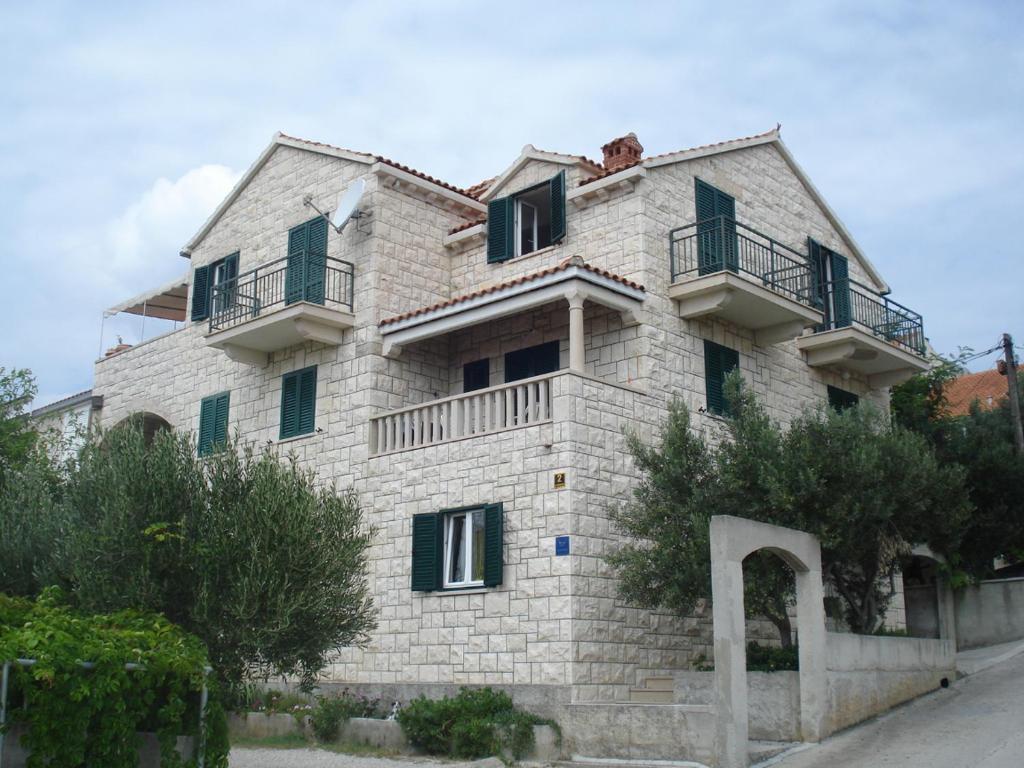 a large stone building with green shuttered windows at Apartments Marin in Bol