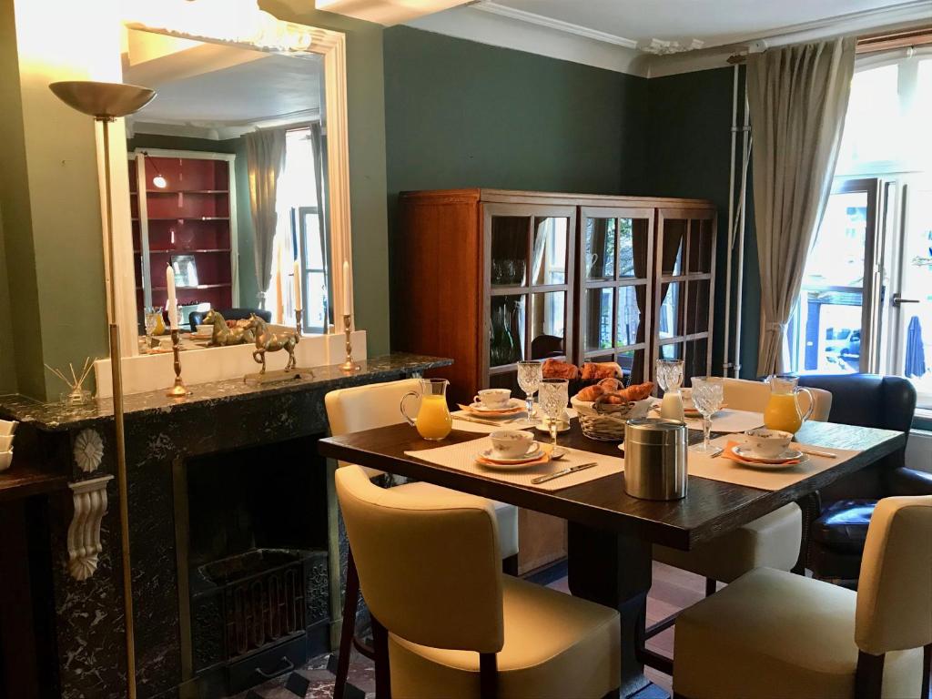 een eetkamer met een tafel en een spiegel bij B&B Au Lion D'or in Maastricht