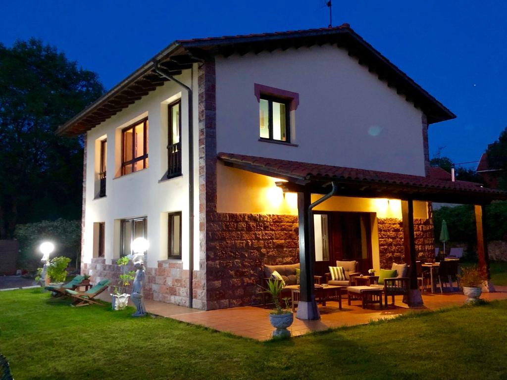 a white house with a patio at night at Casa frente a los Bufones de Pria in Llames de Pría