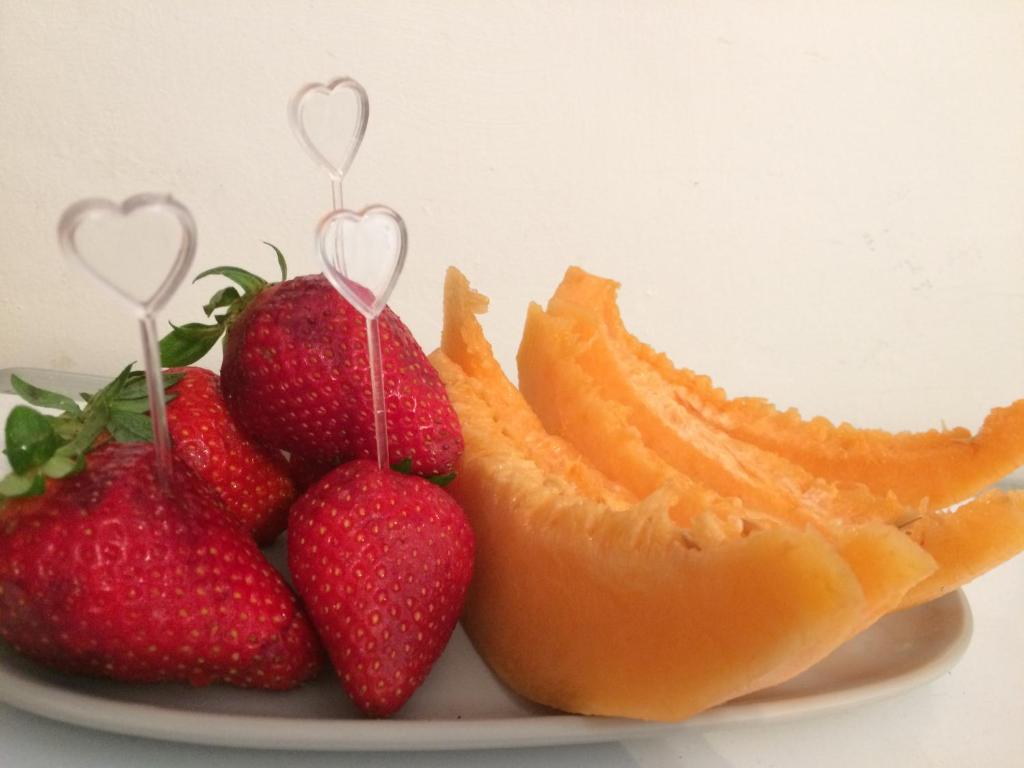 a plate with strawberries and oranges on a plate at Dimore di Mare in San Pietro Vernotico