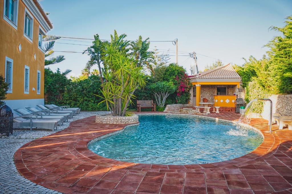 een zwembad met een fontein in een tuin bij Moonshine Guest House with private studios and private cottage in Lagos