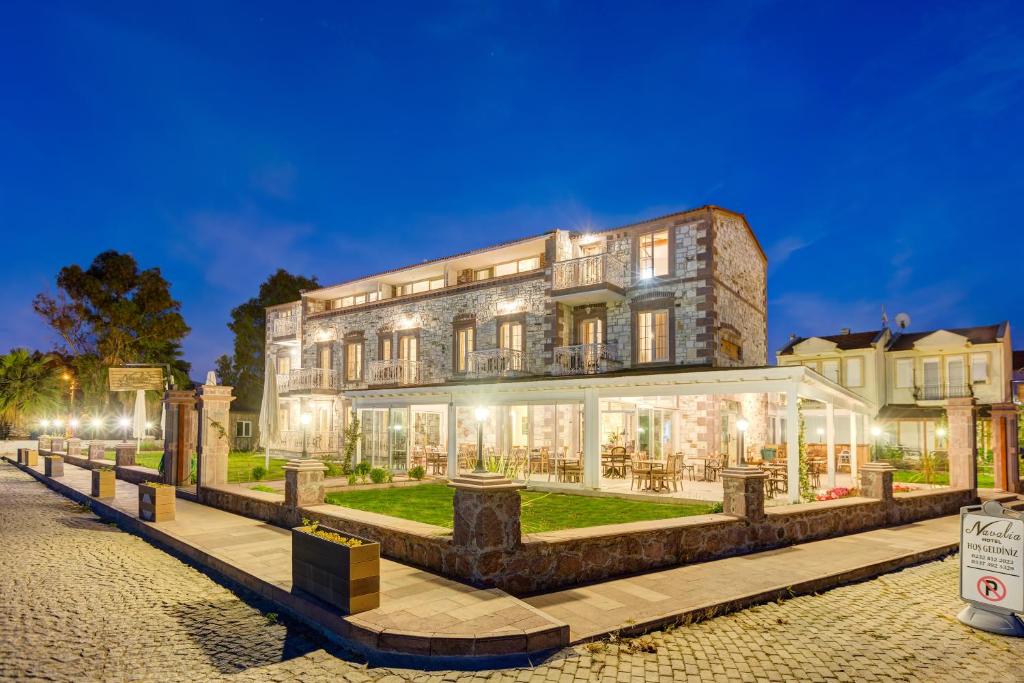 a large building with lights on it at night at Navalia Hotel in Foça