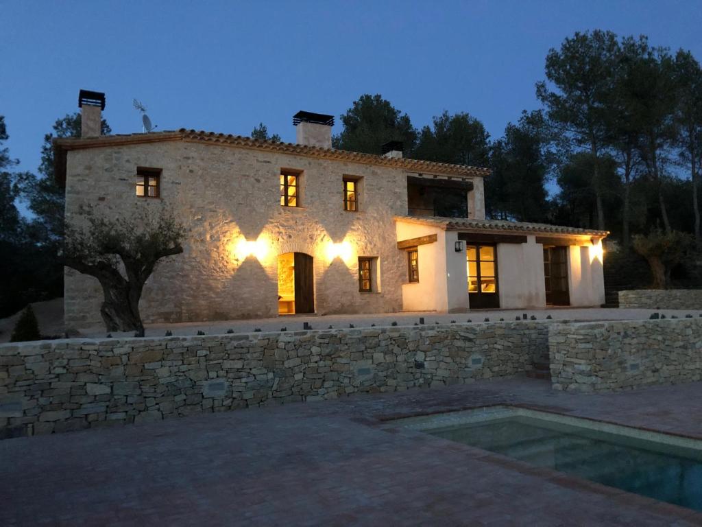 una gran casa de piedra con una pared de piedra en CAL PUIG, ENOTURISMO RURAL entre Viñas y Bosques, en Juncosa