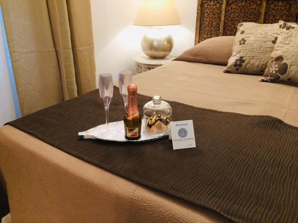 a bed with a tray with a bottle of champagne and glasses at Dimore di Mare in San Pietro Vernotico