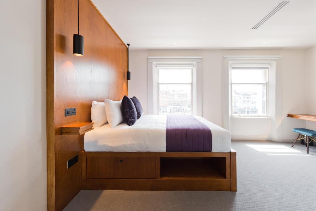 sypialnia z łóżkiem z drewnianym zagłówkiem w obiekcie Templebar Rooms w Dublinie