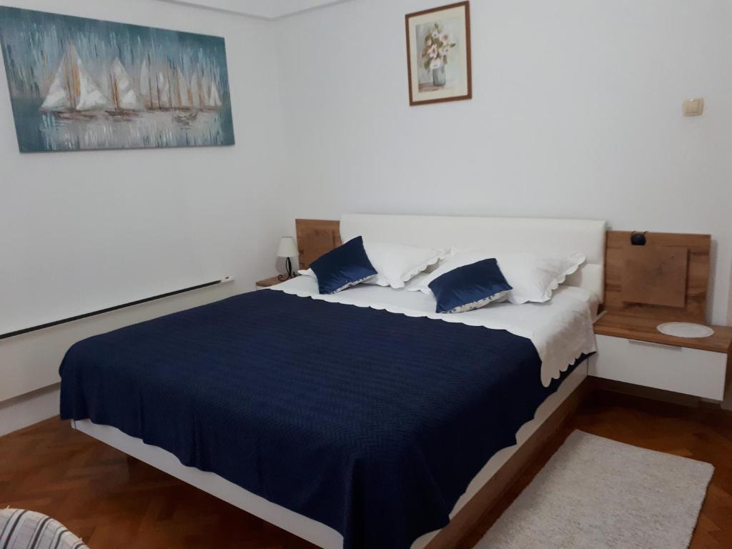 - une chambre dotée d'un grand lit avec des draps et des oreillers bleus dans l'établissement Apartman Jelinić, à Split