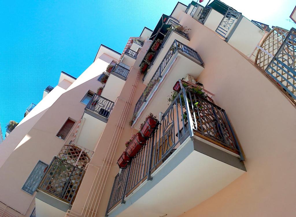 a large white building with balconies on it at Be Inn in Salerno