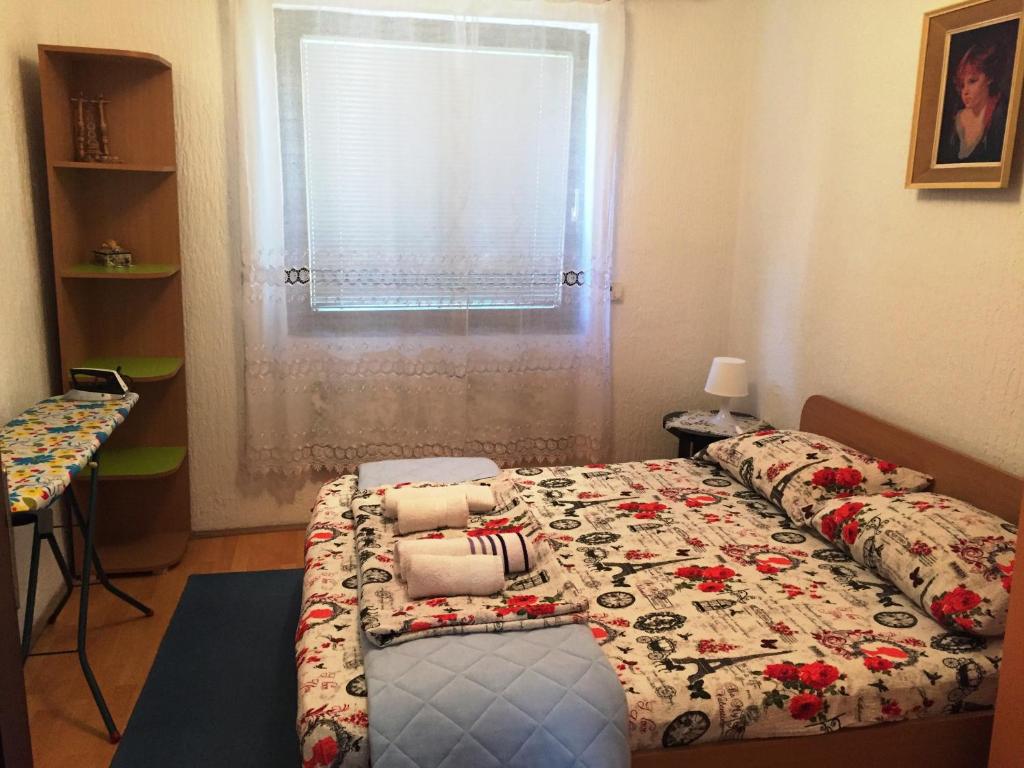 a bedroom with a bed and a window at Niš Apartman in Niš