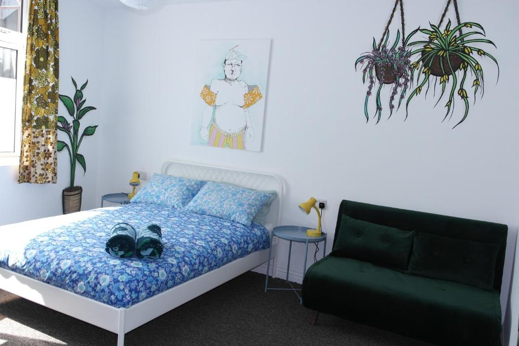 a bedroom with a bed and a green couch at Igloo Hybrid in Nottingham