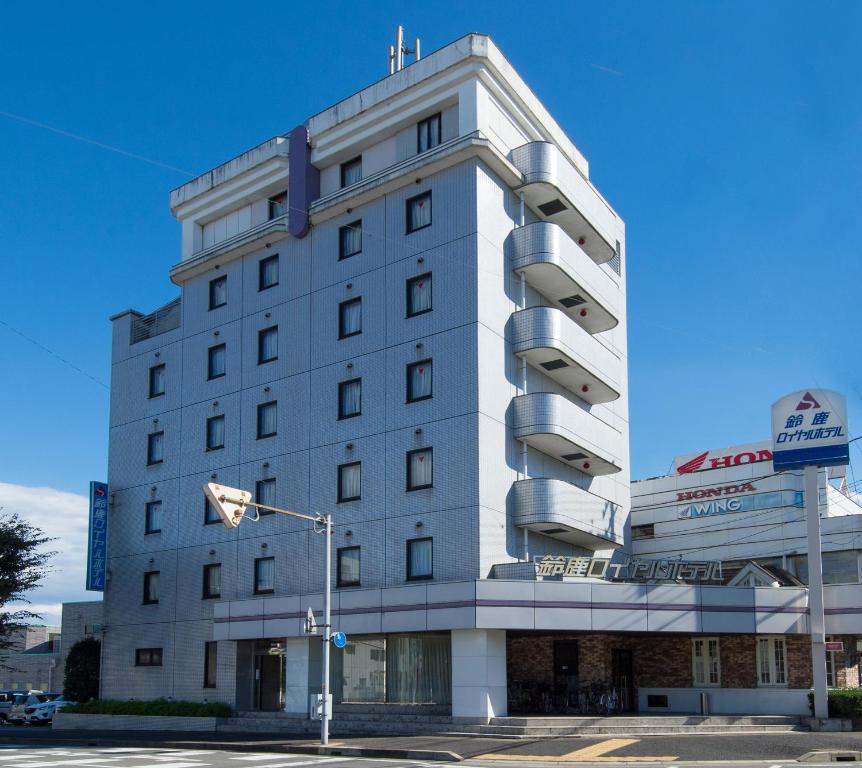 Suzuka Royal Hotel في سوزوكا: مبنى ابيض عليه لافته جانبيه