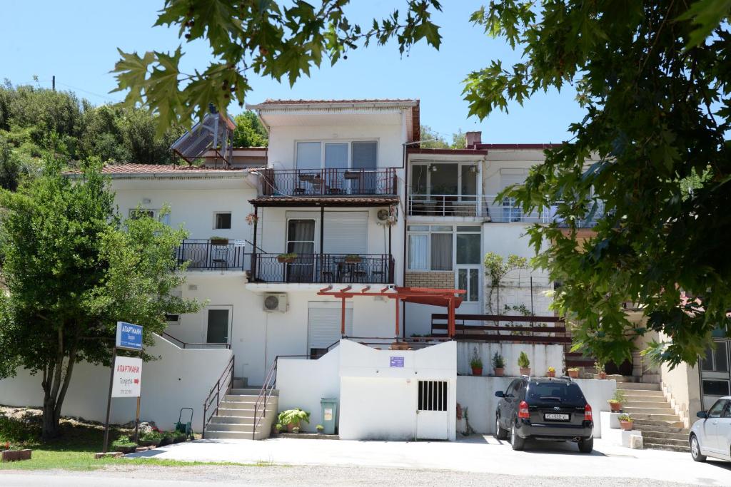 Un grand bâtiment blanc avec des escaliers se trouve juste devant. dans l'établissement Apartmani Teodora, à Nov Dojran