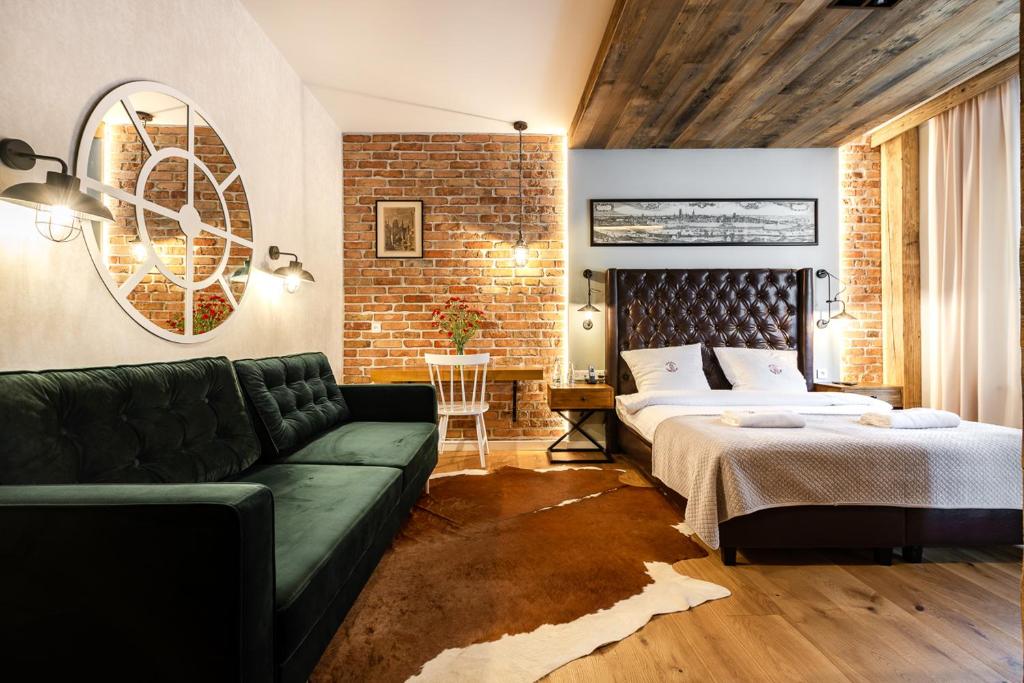 a bedroom with a bed and a green couch at Gotyk House in Gdańsk