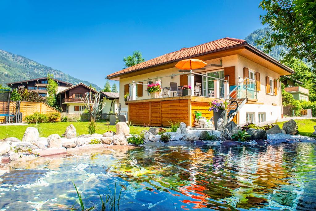 a house with a pond in front of a house at Achen Villa in Bad Hofgastein