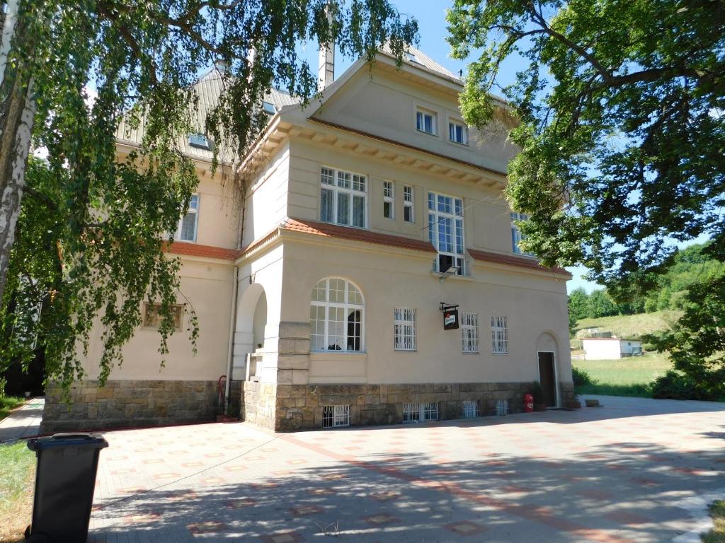 une grande maison blanche avec une grande allée. dans l'établissement Vila Arnau, à Hostinné