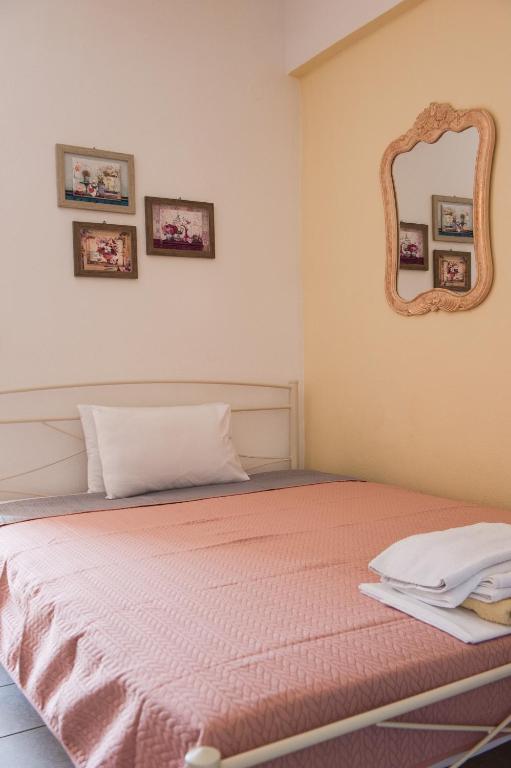 a bedroom with a bed with a mirror on the wall at Maria Village in Vourvourou