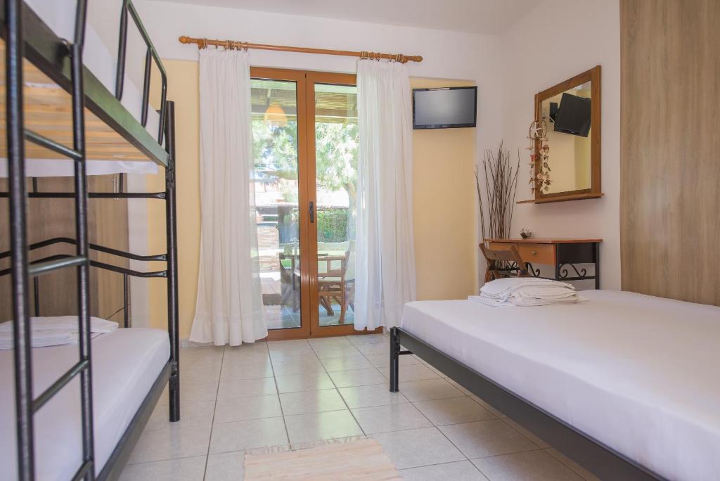 a bedroom with two bunk beds and a balcony at Maria Village in Vourvourou