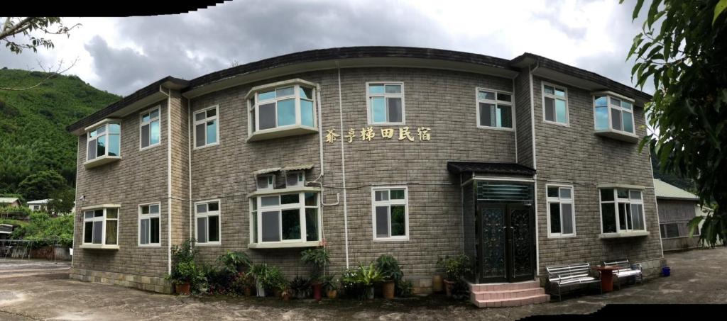 un edificio de ladrillo marrón con un cartel. en Yeheng Terrace Homestay, en Sanguang