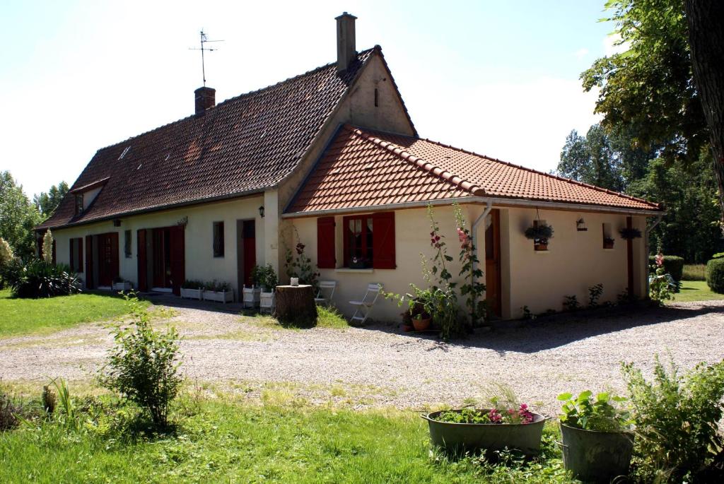 una pequeña casa blanca con techo rojo en Au Retour du Lac, en Ardres