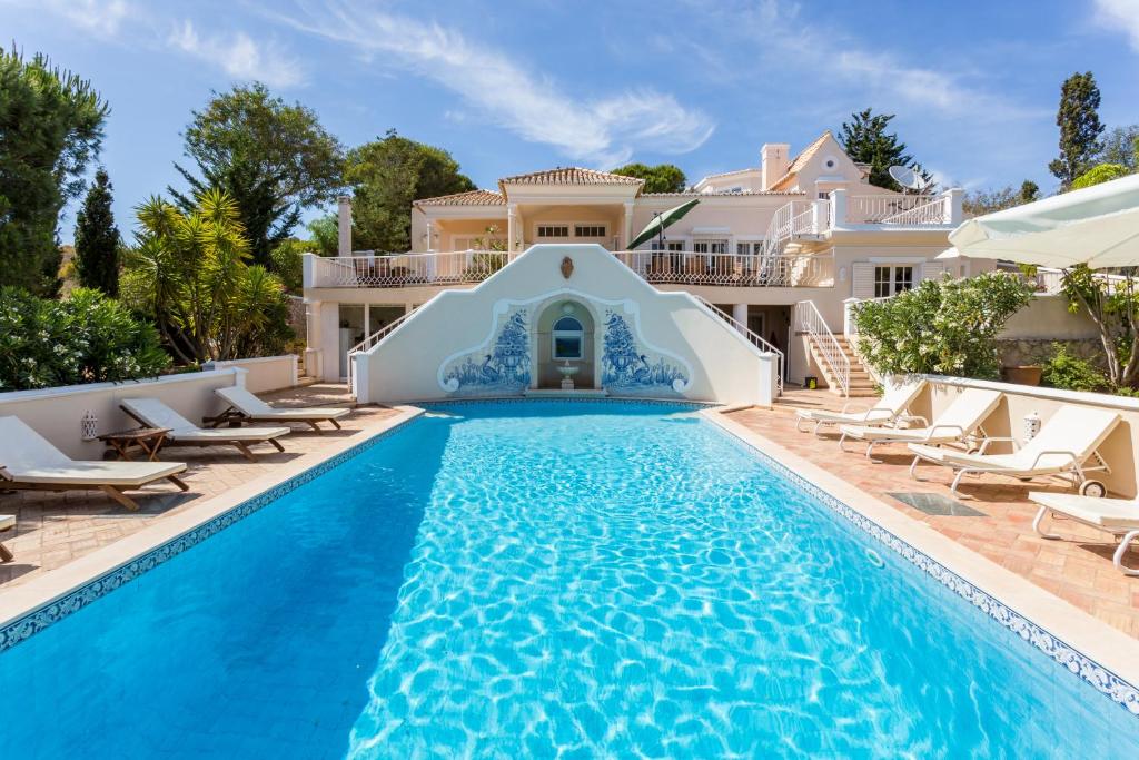 a villa with a swimming pool in front of a house at Top Cliff Villa with ocean view and pool at stunning cliffs in Burgau