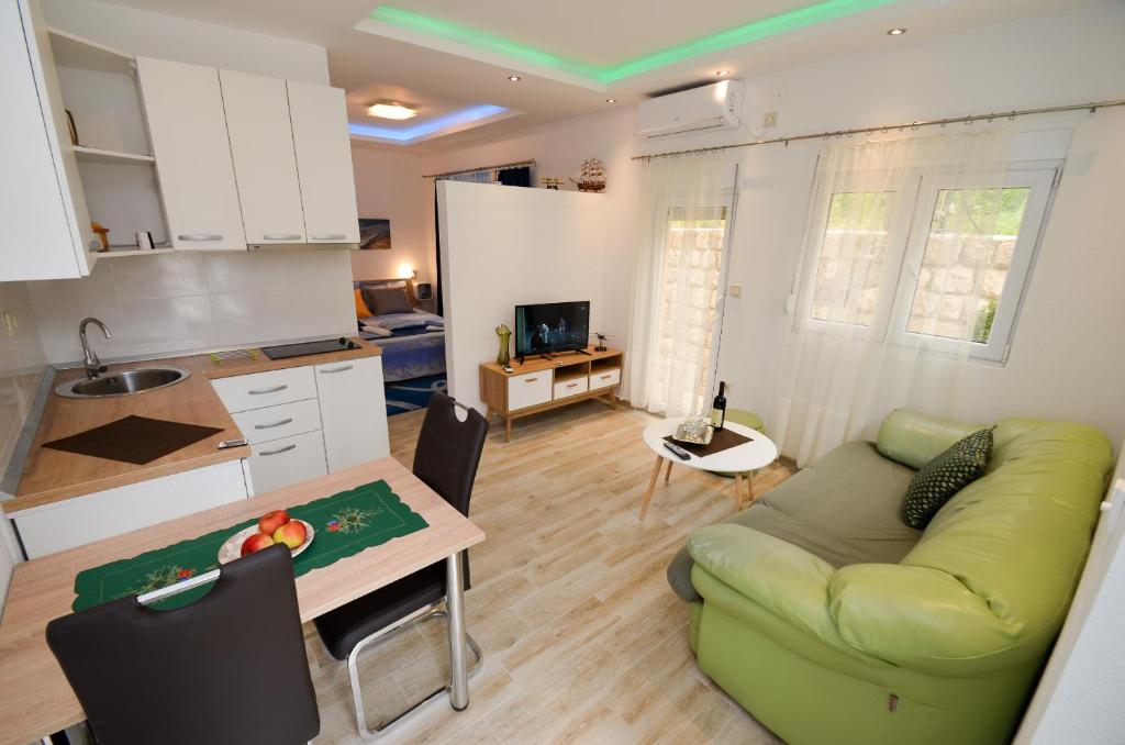 a kitchen and a living room with a couch and a table at Apartment The Sea Coast in Kotor