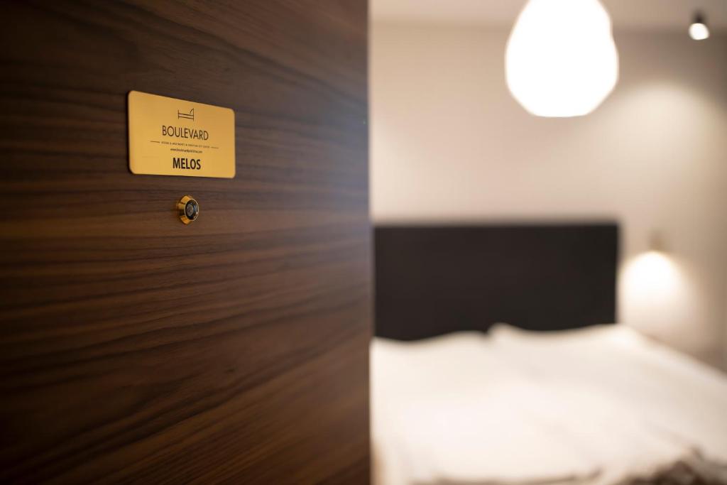 a hotel room with a bed and a sign on the wall at Boulevard Center 92 in Pristina