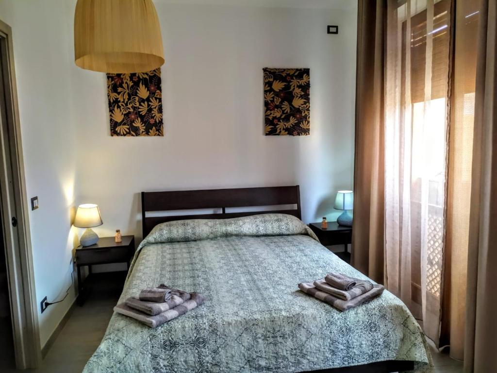 een slaapkamer met een bed met twee handdoeken erop bij B&B Libellula in Iglesias