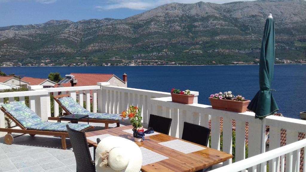 een tafel en stoelen op een balkon met uitzicht op het water bij Apartman Mali Tare in Korčula