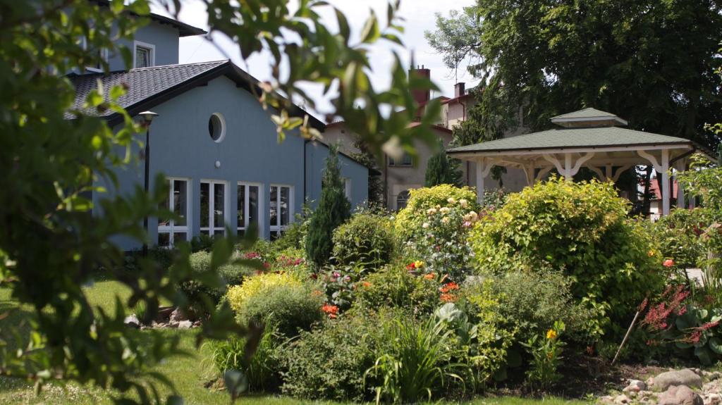 a blue house with a gazebo in a garden at Eden in Wisełka