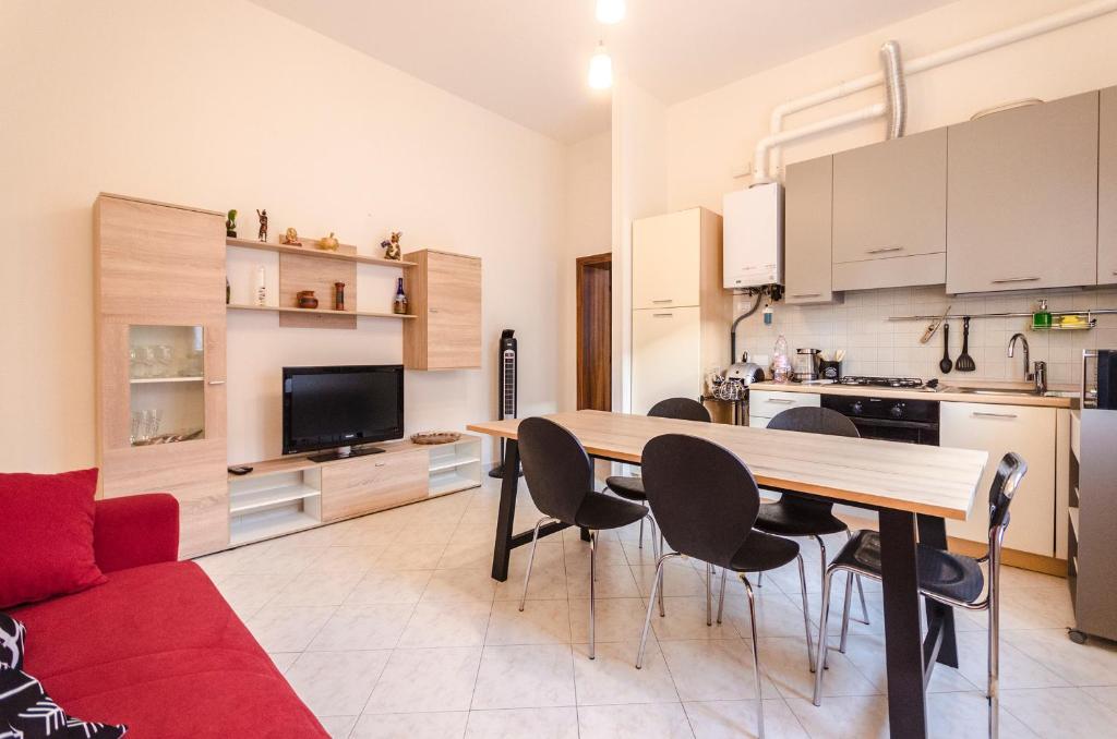 eine Küche und ein Wohnzimmer mit einem Tisch und Stühlen in der Unterkunft Emil's House, Spazioso appartamento con 3 camere in Bologna