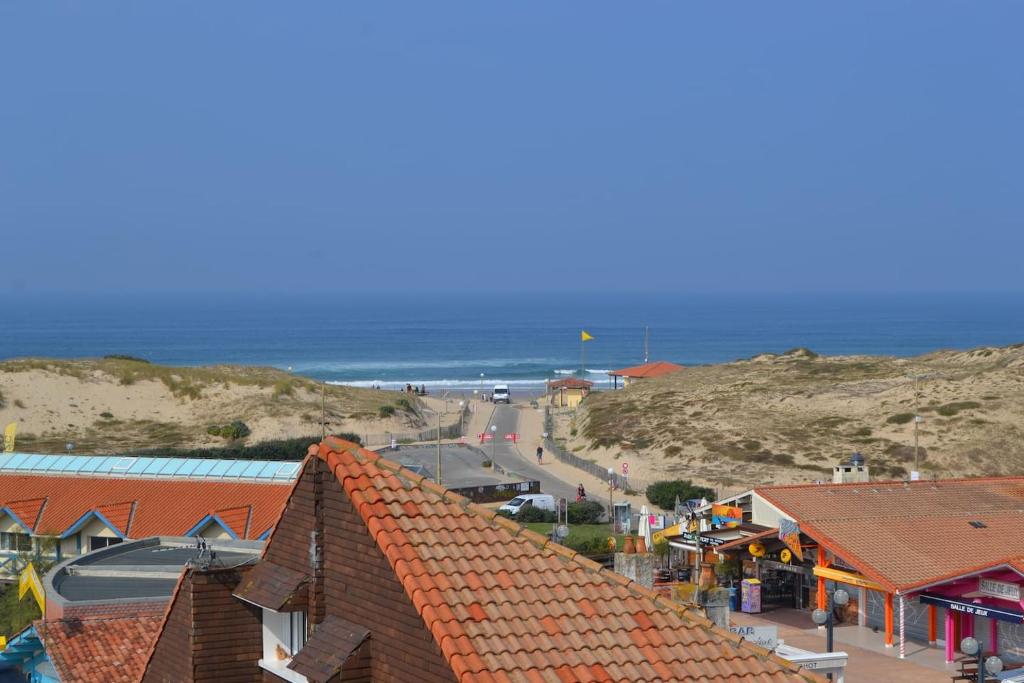 Blick auf einen Strand mit Häusern und das Meer in der Unterkunft vue océan à Seignosse in Seignosse