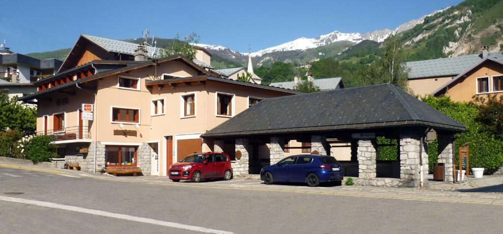 due auto parcheggiate di fronte a un edificio di Hôtel Arolla a Bourg-Saint-Maurice