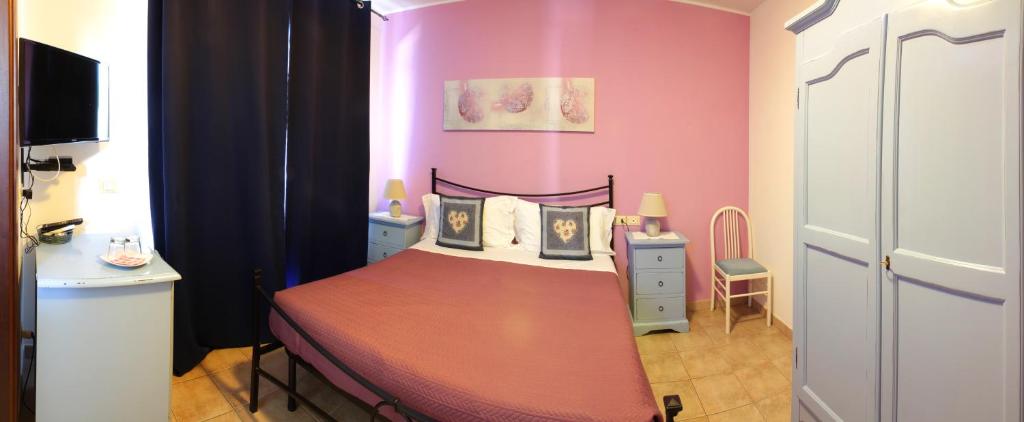 a bedroom with a bed and a pink wall at Country House La Foggetta in Pineto
