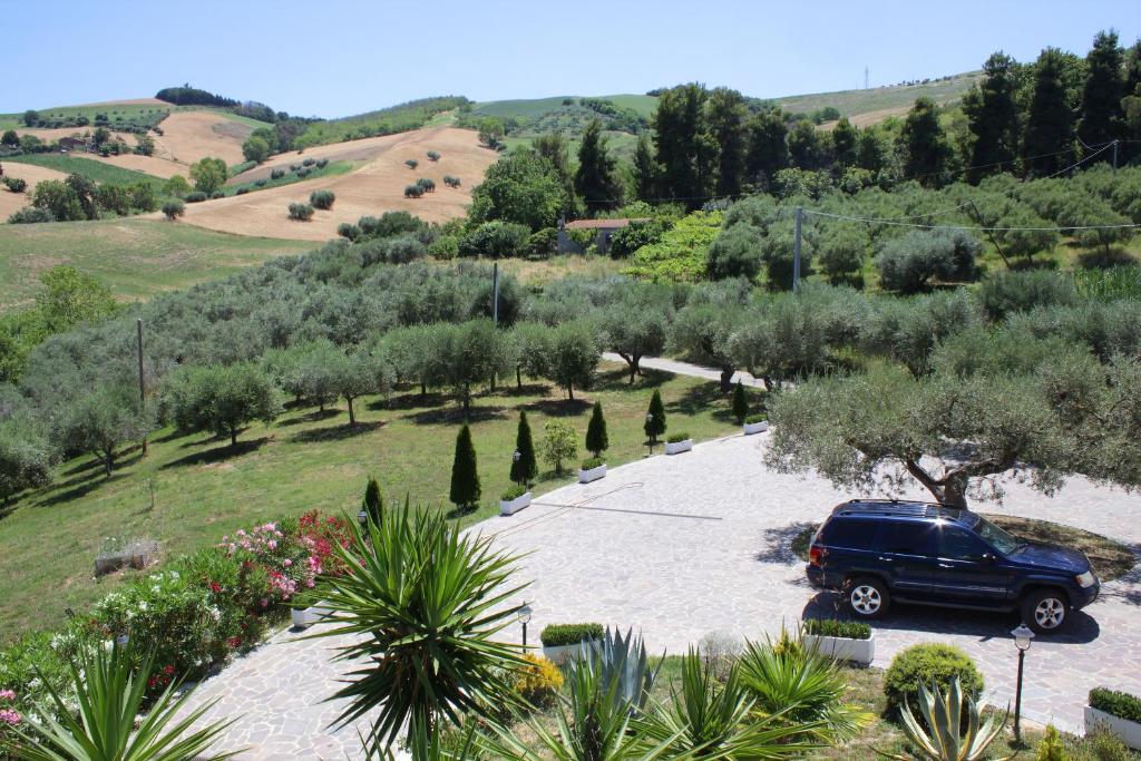 a car parked in a parking lot in a garden at Country House La Foggetta in Pineto