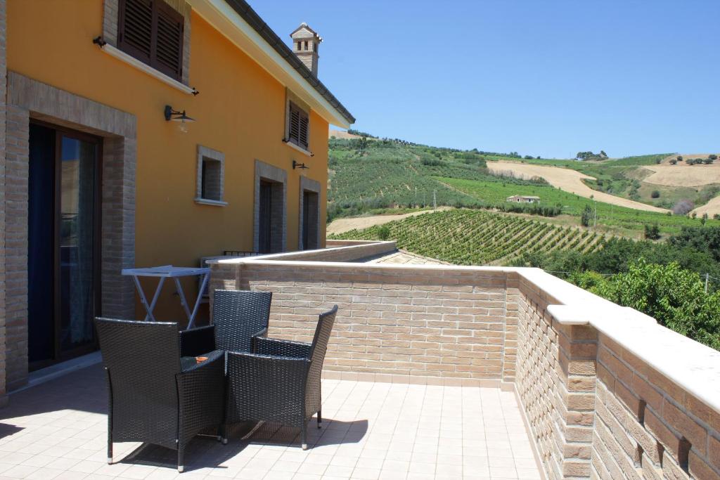 a patio with two chairs and a brick wall at Country House La Foggetta in Pineto