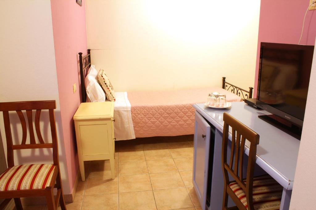 a small room with a bed and a television at Country House La Foggetta in Pineto