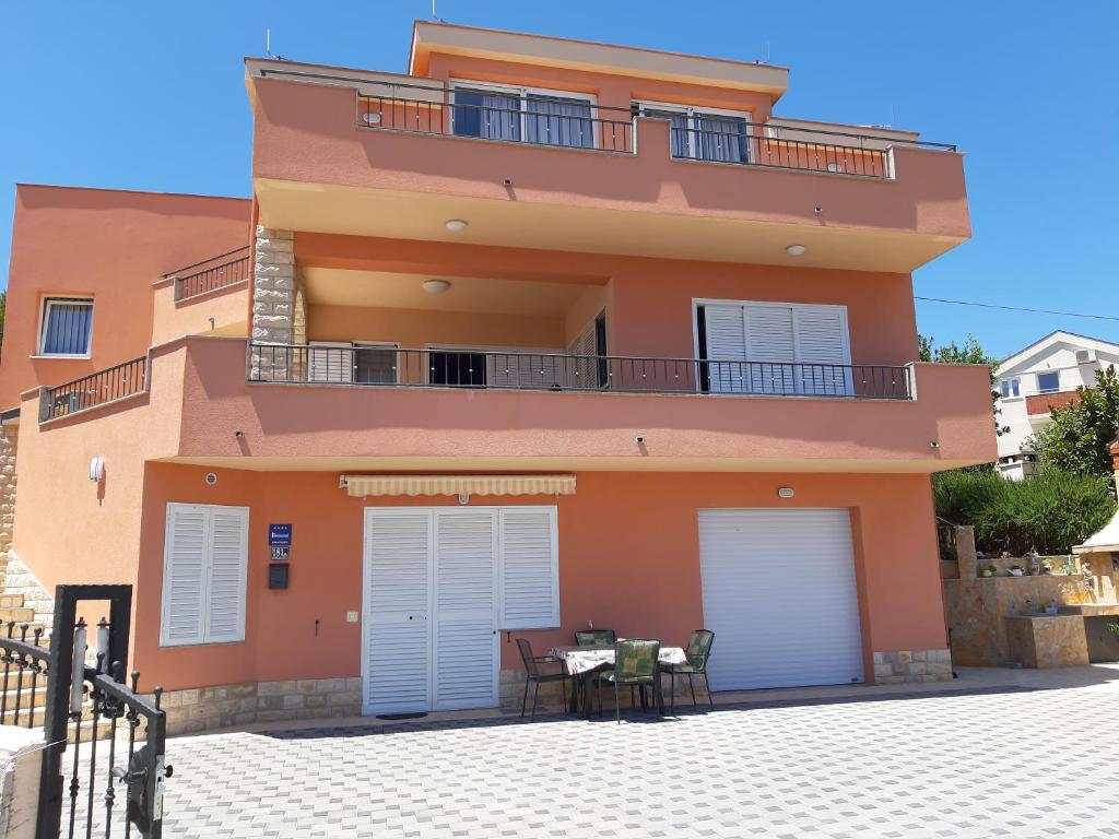 a orange building with two garage doors and a table at Regina del Mare in Slatine