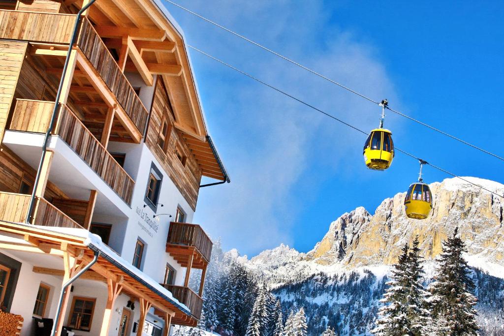 a pair of ski lifts in front of a mountain at Garnì La Tranquillitè in Corvara in Badia