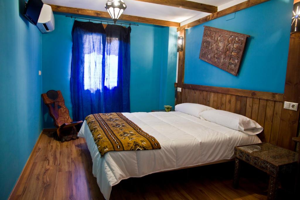 a bedroom with blue walls and a bed in a room at Hotel Plaza in Cuenca