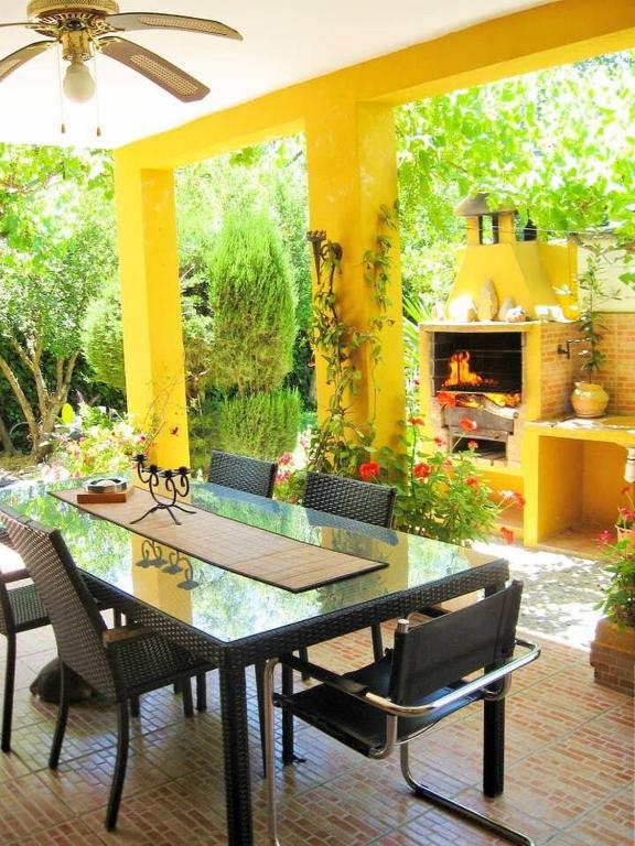 a patio with a table and chairs and a fireplace at Casa Rural Los Membrillos in Teba