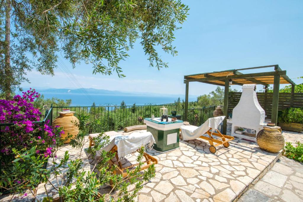 a patio with a table and chairs and a gazebo at Villa Eleonas in Ieromónachos