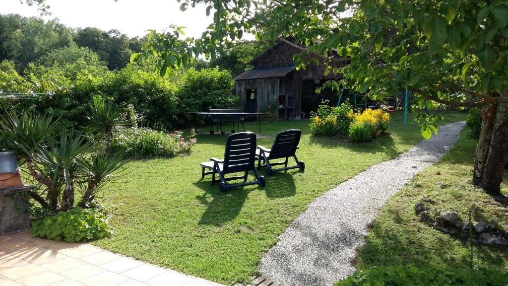 2 sillas y una mesa en un jardín en 21 rue de l'Olivet en Orbigny