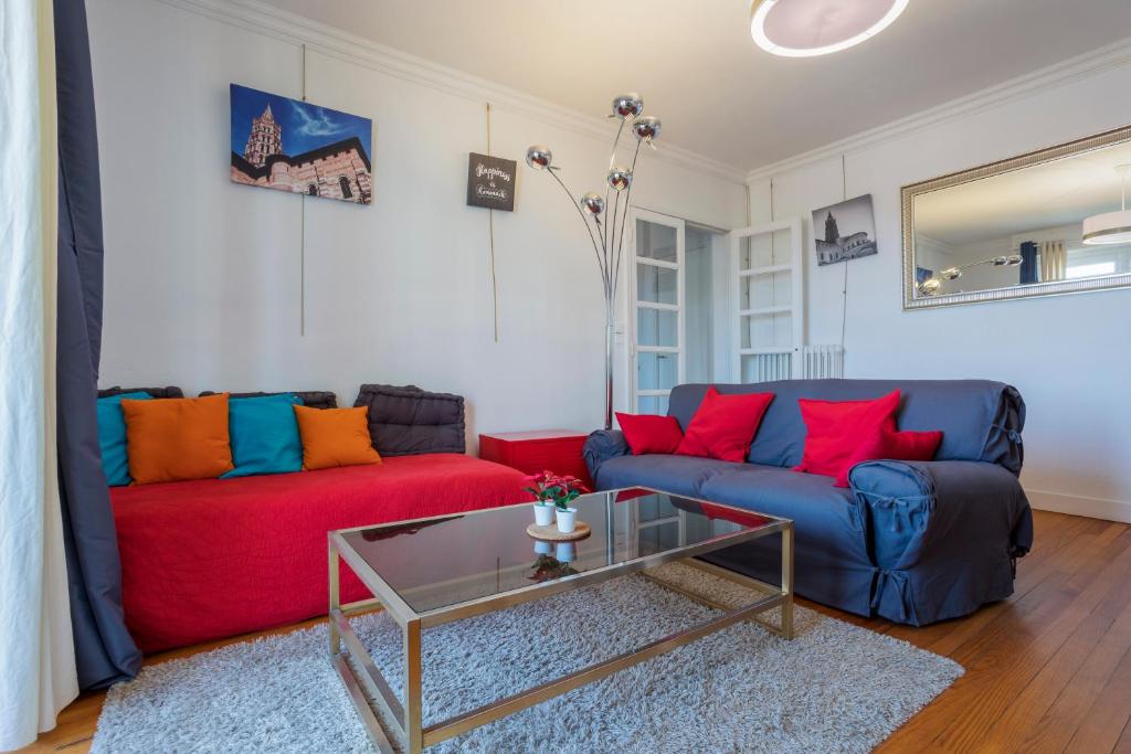 un salon avec deux canapés et une table en verre dans l'établissement Les terrasses de Toulouse Compans, à Toulouse