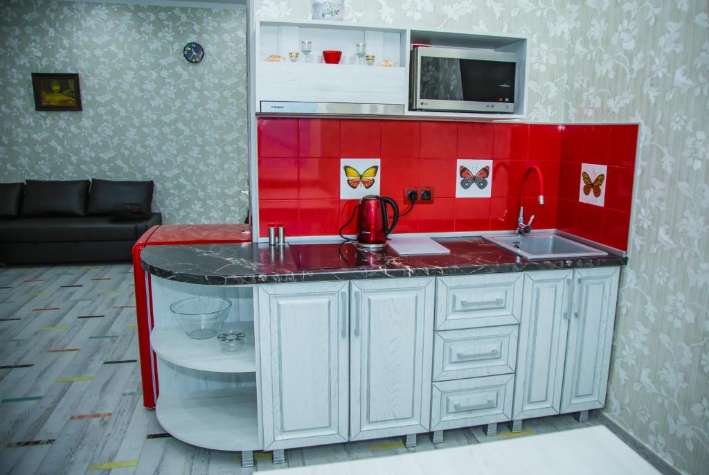 a kitchen with a sink and a red wall at Guest house Forest in Pyatigorsk