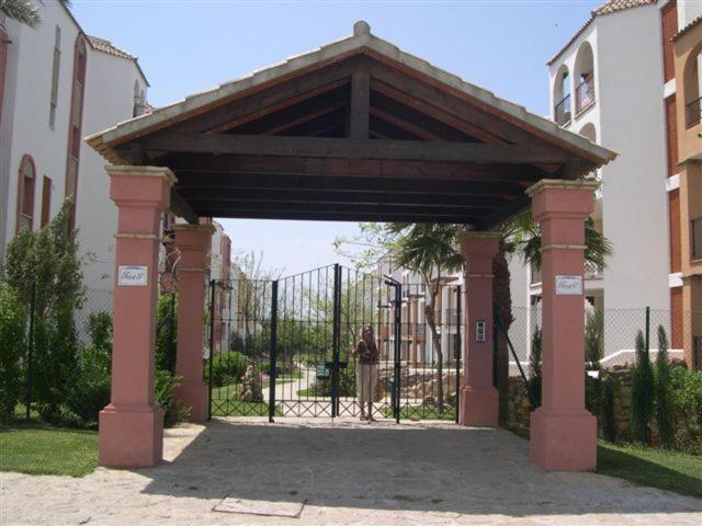 a woman standing under a gate in front at Apartamentos Atlanterra COSTA Y SOL in Zahara de los Atunes