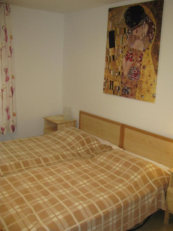 1 dormitorio con 1 cama y una pintura en la pared en Ferienwohnung Herbsleben, en Herbsleben
