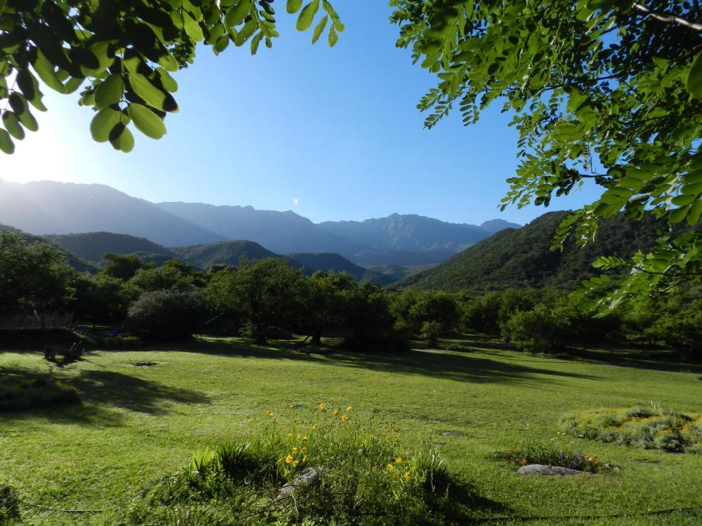 a field of grass with mountains in the background at Cabañas Entrelomas in Nono