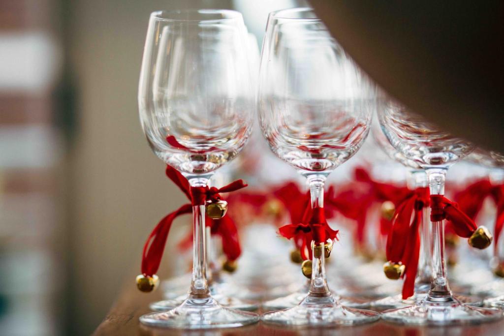 four wine glasses sitting on a table with red bows at AVANTI Lifestyle Hotel - Only Adults in Corralejo